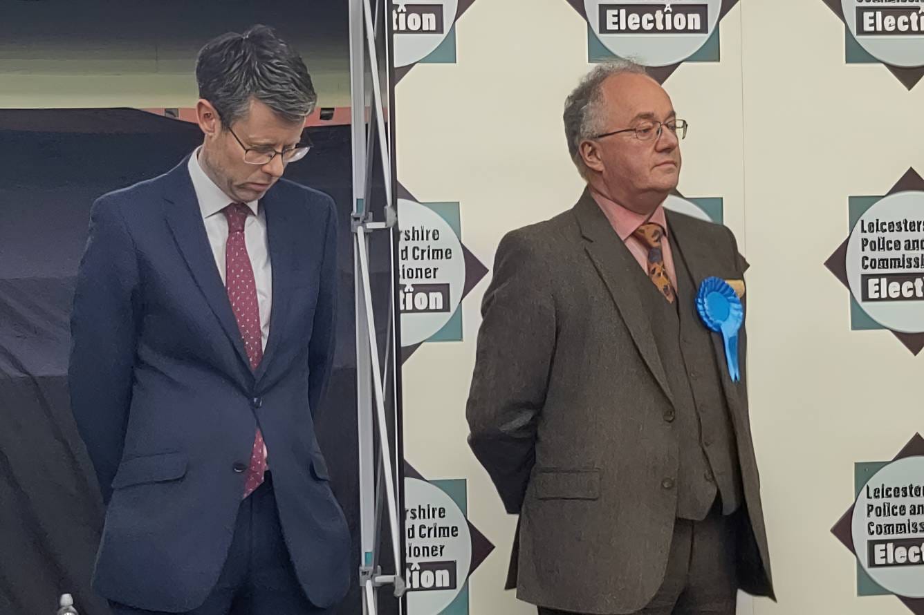 Rory Palmer stands on stage next to Rupert Matthews as the results are announced.